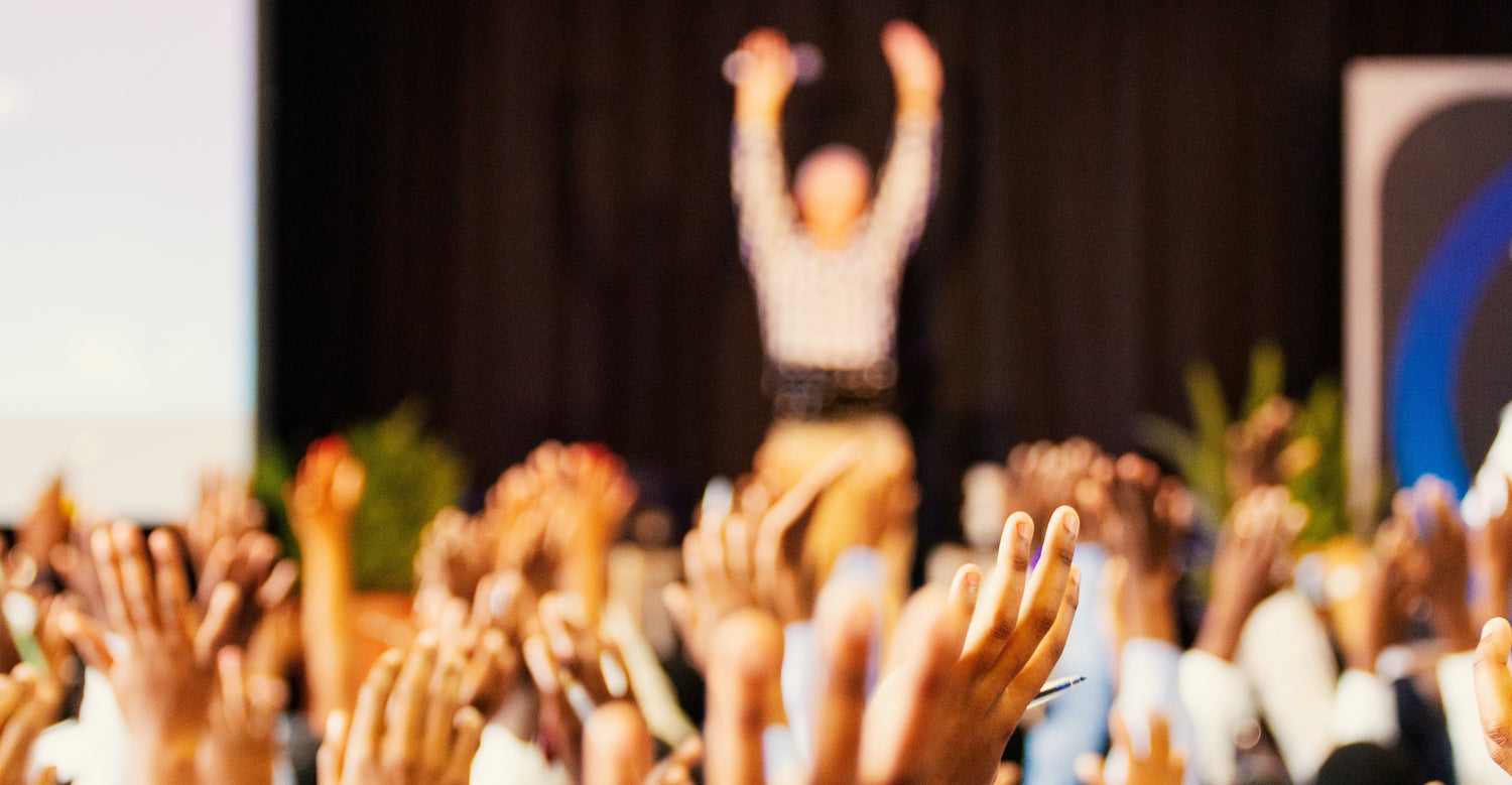 People raising their hands at an event